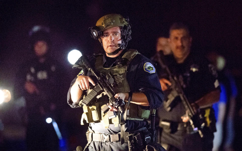 FILE - In this July 28, 2019 file photo, police officers escort people from Christmas Hill Park following a deadly shooting during the Gilroy Garlic Festival, in Gilroy, Calif. The FBI has labeled two of those attacks, at a Texas Walmart and the California food festival, as domestic terrorism — acts meant to intimidate or coerce a civilian population and affect government policy. But the bureau hasn't gone that far with a shooting at an Ohio entertainment district. (AP Photo/Noah Berger, File)