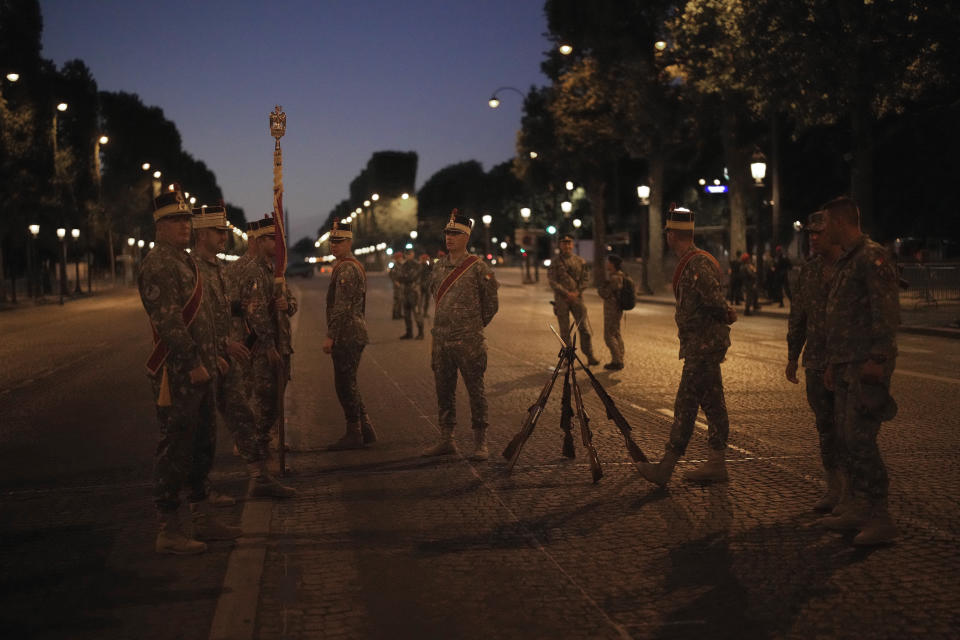 Soldiers of Romania stand on the Champs Elysees avenue during a rehearsal for the Bastille Day parade in Paris, France, Monday, July 11, 2022. Paris is preparing for a big Bastille Day parade later this week, a military show on the Champs-Elysees avenue that this year will honor war-torn Ukraine and include troops from countries on NATO's eastern flank: Poland, Hungary, Slovakia, Romania, Bulgaria, Czechia, Lithuania, Estonia and Latvia. (AP Photo/Christophe Ena)
