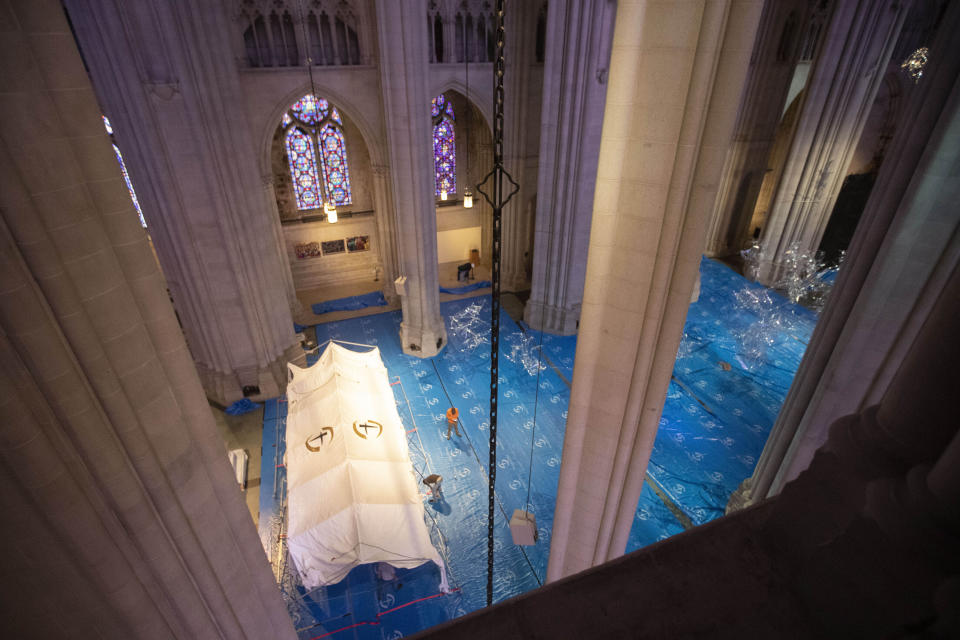 In this April 8, 2020 photo, volunteers raise a tent in the nave while building a field hospital at Cathedral of St. John the Divine in New York. The Cathedral of St. John the Divine had partnered with Mount Sinai Health System and the evangelical Christian organization Samaritan's Purse to provide as many as 200 treatment beds in the church, but the hospital system decided the space was not needed. (AP Photo/Mary Altaffer)