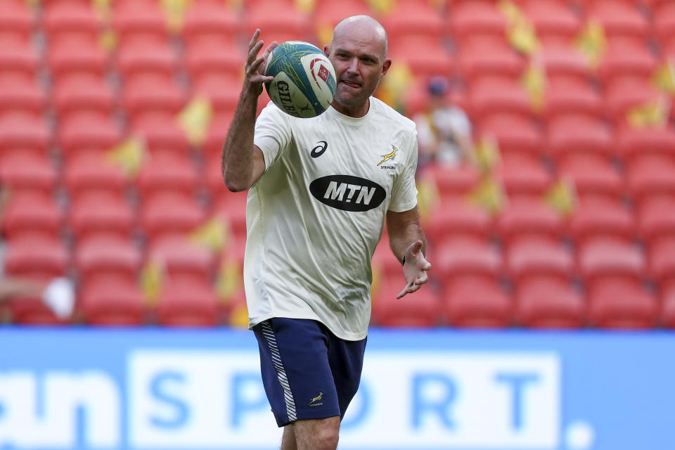 South Africa's coach Jacques Nienaber catches the ball as he watches his players warm up ahead of the Rugby Championship test match between the Springboks and the Wallabies in Brisbane, Australia, Saturday, Sept. 18, 2021. (AP Photo/Tertius Pickard)