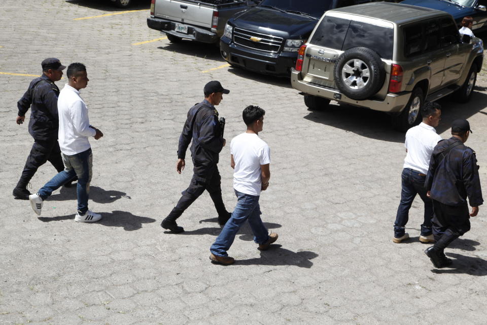 Men accused in the killing prize-winning Honduran indigenous and environmental rights activist Berta Caceres are escorted for trail in Tegucigalpa, Honduras, Monday, Sept. 17, 2018. Honduras' supreme court has indefinitely suspended the start of the trial of eight men accused in the 2016 killing of Caceres, citing five related filings pending at the criminal appeals court that have to be resolved. (AP Photo/Fernando Antonio)