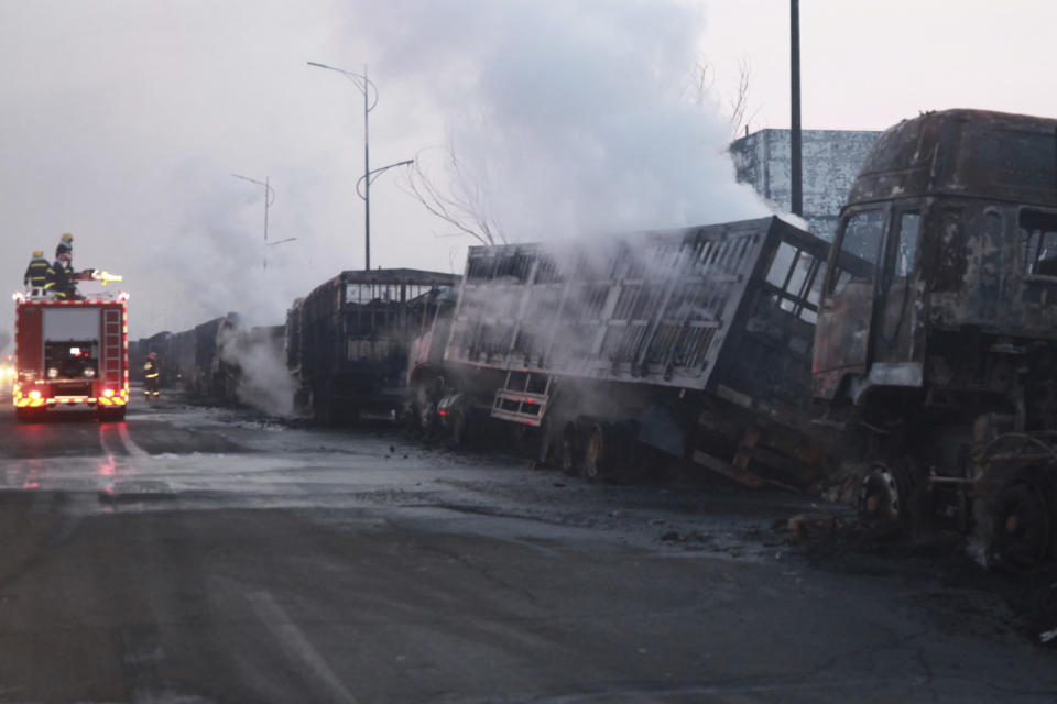 In this photo released by Xinhua News Agency, firefighters try to extinguish burning vehicles in the aftermath of an explosion at a plant operated by the Hebei Shenghua Chemical Industry Co. Ltd that destroyed dozens of vehicles nearby on Wednesday, Nov. 28, 2018 in Zhangjiakou city, northeastern China's Hebei province.(Xinhua via AP)