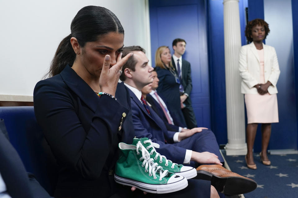 Camila Alves McConaughey sostiene unos tenis Converse verdes que pertenecieron a la víctima del tiroteo de la primaria de Uvalde Maite Yuleana Rodriguez,  de 10 años, mientras Matthew McConaughey, originario de Uvalde, Texas, acompaña a la secretaria de prensa Karine Jean-Pierre durante el informe diario de la Casa Blanca en la Casa Blanca el 7 de junio de 2022 en Washington. (Foto AP/Susan Walsh)