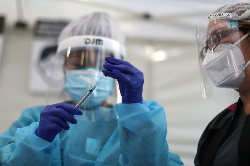 FILE PHOTO: Healthcare workers prepare Pfizer coronavirus disease (COVID-19) vaccinations in Los Angeles