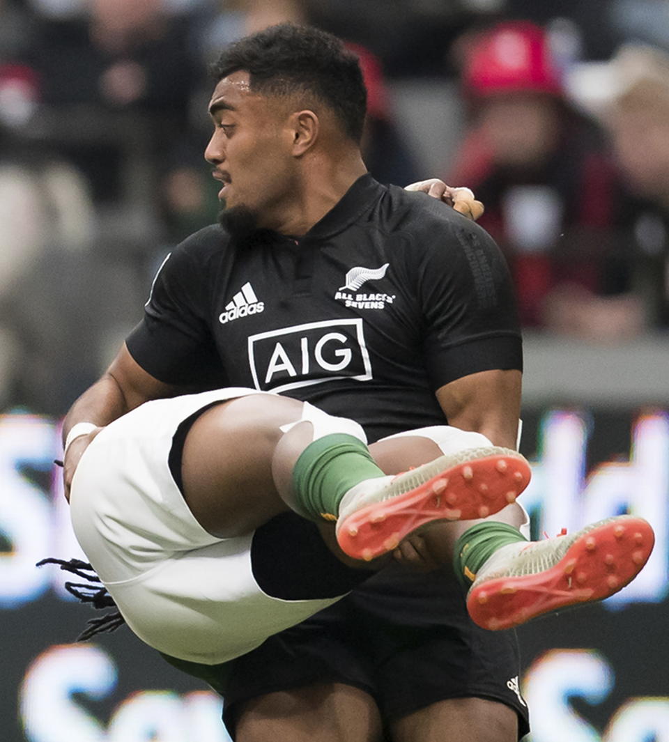 New Zealand's Tone Ng Shiu upends South Africa's Branco du Preez, back, during a semifinal match at the Canada Sevens rugby tournament in Vancouver, British Columbia, Sunday, March 8, 2020. (Darryl Dyck/The Canadian Press via AP)