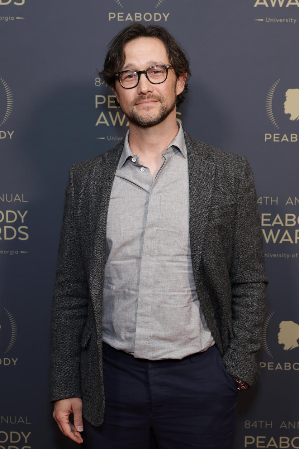 Joseph Gordon-Levitt in a casual blazer and shirt, standing on the red carpet at the 84th annual Peabody Awards