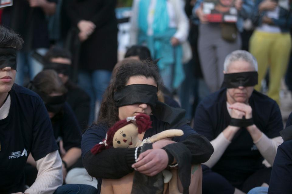 Protesters wear blindfolds to highlight the children, women and men being held by Hamas in the Gaza Strip during a rally on Dec. 11, 2023, in Holon, Israel. Following a weeklong truce in late November that saw the release of 105 captives, 138 hostages are still believed to be held in Gaza.