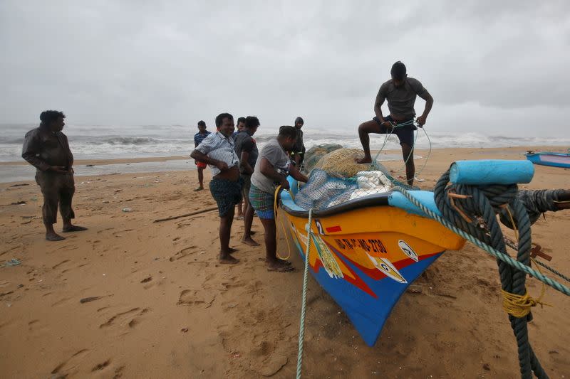 Fishermen tie their boat on the shore before Cyclone Nivar's landfall, in Chennai