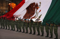 Soldiers hold a Mexican national flag as it is raised at half-staff during the 34th anniversary of the 1985 earthquake, in Mexico City, Thursday, Sept. 19, 2019. The 8.1-magnitude earthquake killed as many as 10,000 and left thousands homeless. The date also commemorates the 2017 earthquake that rattled the city killing hundreds. (AP Photo/Marco Ugarte)
