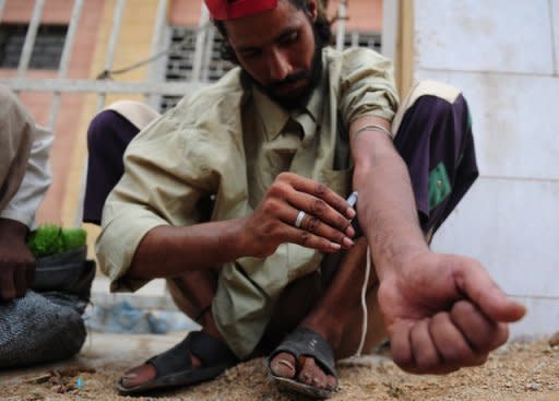 A Pakistani heroin addict self-injects on a street in Karachi. Some 27 million people worldwide are problem drug users, with almost one percent every year dying from narcotics abuse, while cannabis remains the most popular drug, a UN report showed Tuesday