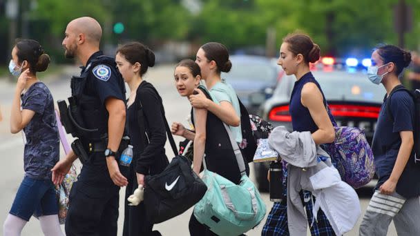 PHOTO: People are escorted away from the scene of a mass shooting at a Fourth of July parade in Highland Park, Ill., on July 4, 2022.  (John Starks/AP)