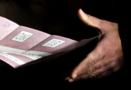 A man takes his ballot during the referendum on constitutional reform, in Pontassieve, near Florence, northern Italy December 4, 2016. REUTERS/Paolo Lo Debole