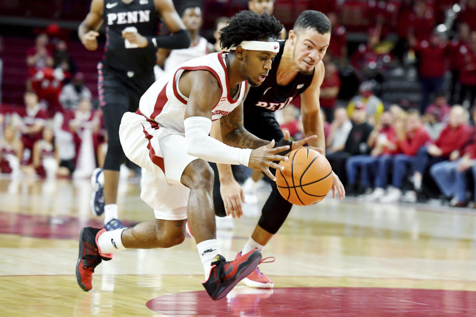 Arkansas guard Chris Lykes (11) drives past Pennsylvania guard Jelani Williams (5) on a fast break during the first half of an NCAA college basketball game Sunday, Nov. 28, 2021, in Fayetteville, Ark. (AP Photo/Michael Woods)