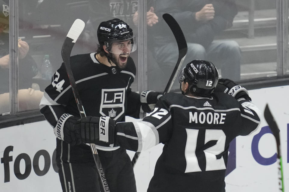 Los Angeles Kings center Phillip Danault (24) celebrates with left wing Trevor Moore (12) after scoring during the third period of an NHL hockey game against the Calgary Flames Thursday, Dec. 22, 2022, in Los Angeles. (AP Photo/Ashley Landis)