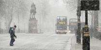 <p>Pedestrians cross Whitehall as snow falls in London.A warning of heavy snow showers is in place for east England, London and the south-east, and the Midlands until 10am. (AP Photo/Alastair Grant) </p>