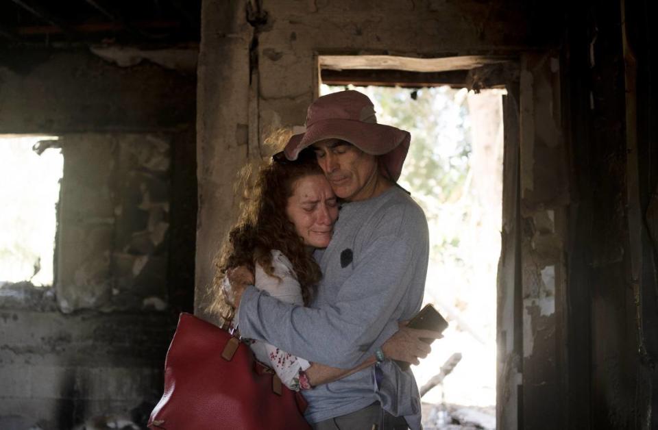 Residents of Kibbutz Nir Oz in southern Israel weep together in the ruins of the home of Carmela Dan, 80, Monday, Oct. 30, 2023. She was killed when the kibbutz was overran by Hamas militants on Oct. 7, killing or capturing a quarter of its community.