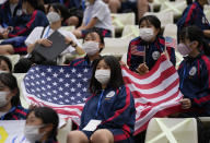 School kids hold a U.S. flag as they wait a women's soccer match between United States and Australia at the 2020 Summer Olympics, Tuesday, July 27, 2021, in Kashima, Japan. (AP Photo/Fernando Vergara)