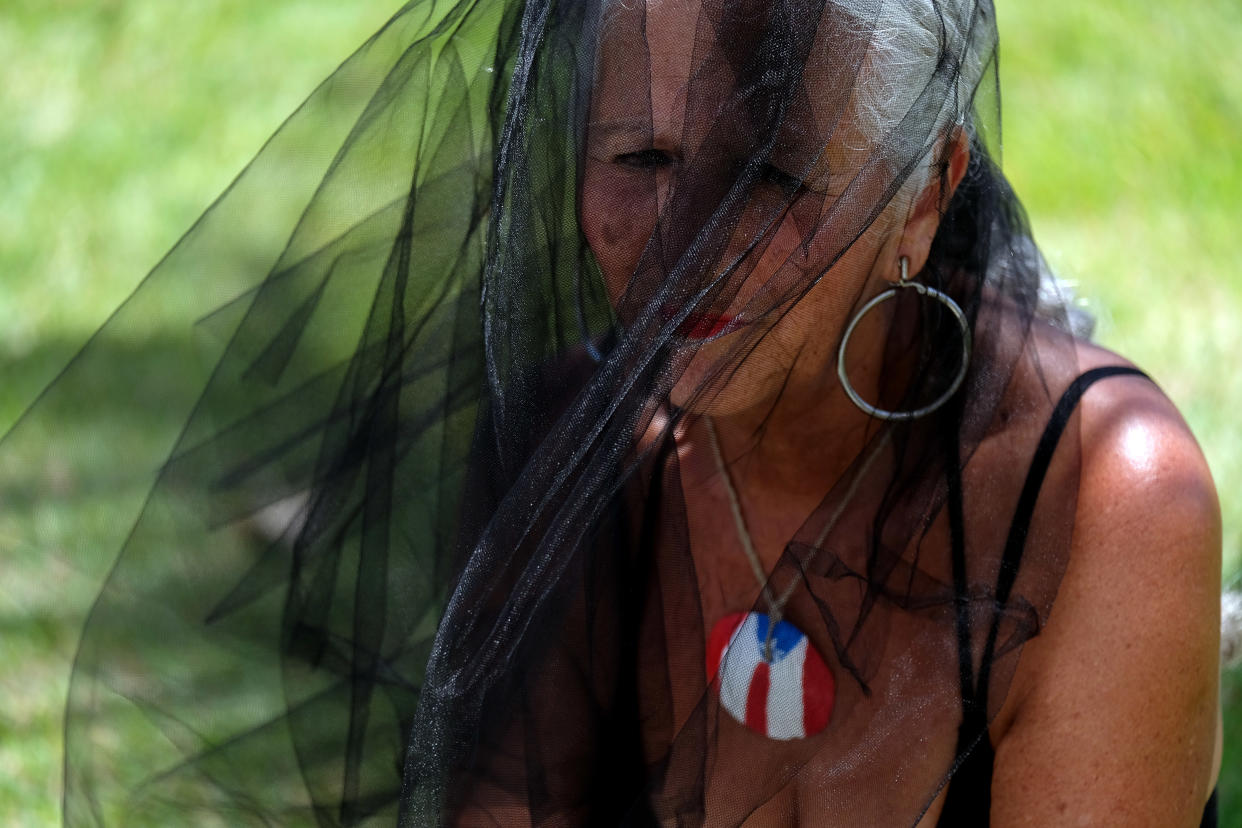 Aida Cruz Alicea, 68, prays in front of hundreds of shoes that were displayed in memory of those killed by Hurricane Maria, in front of the&nbsp;Capitol in San Juan, Puerto Rico, June 1. (Photo: RICARDO ARDUENGO / Getty Images)