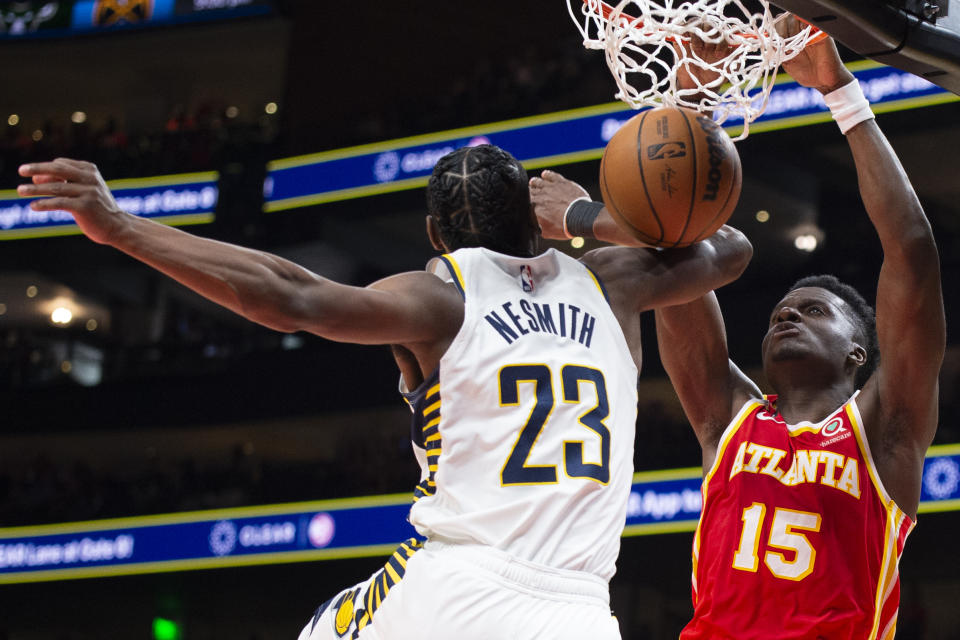 Atlanta Hawks center Clint Capela dunks over Indiana Pacers forward Aaron Nesmith during the first half of an NBA basketball game, Saturday, March 25, 2023, in Atlanta. (AP Photo/Hakim Wright Sr.)