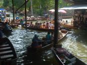 Tourists jostle with merchants selling food, flowers and vegetables in the crowded, busy canal.