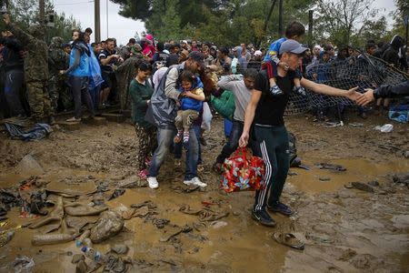 Syrian refugees walk through the mud as they cross the border from Greece into Macedonia, near the Greek village of Idomeni, September 10, 2015. REUTERS/Yannis Behrakis