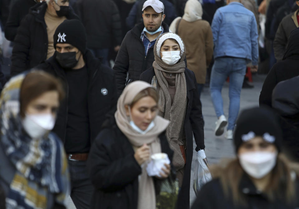 People visit the Grand Bazaar of Tehran, Iran, Saturday, Jan. 22, 2022. After successive virus waves pummeled the country for nearly two years, belated mass vaccination under a new, hard-line president has, for a brief moment, left the stricken nation with a feeling of apparent safety. (AP Photo/Vahid Salemi)