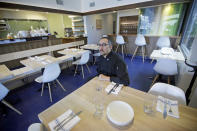 This March 21, 2017, photo, Manoli Katsanevas, the chef and owner of Greek eatery Manoli's sits in his dining room with it's Zion Curtain, in Salt Lake City. Some Utah restaurants are counting down the days until a new liquor law takes effect this summer, allowing eateries to take stop using walls and partitions that prevent customers from seeing their alcoholic drink being mixed and poured. But Katsanevas said he doesn't know yet if state officials will measure the 5-foot zone from the area where drinks are actually prepared, or if they'll measure from the entire length of the bar. If it's the latter, he'll have to keep up his Zion Curtain. (AP Photo/Rick Bowmer)