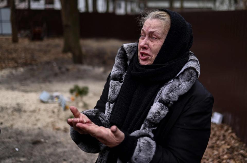 Bucha resident Tetiana Ustymenko weeps over the grave of her son, buried in the garden of her house (AFP via Getty Images)