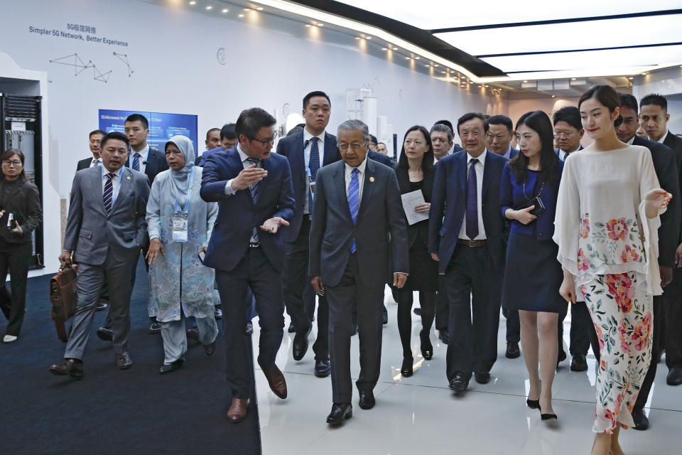 Malaysian Prime Minister Mahathir Mohamad, center, is accompanied by Huawei founder and CEO Ren Zhengfei, third from right, and officials as he visits to Huawei Executive Briefing Center in Beijing, Thursday, April 25, 2019. Mahathir is in Beijing to attend the Belt and Road Forum which start on this weekend. (AP Photo/Andy Wong)