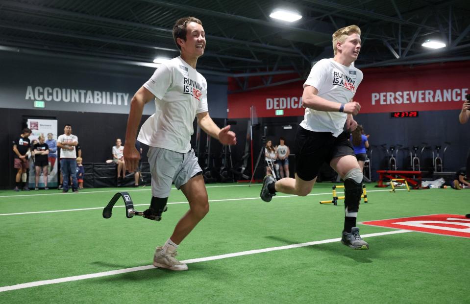 Jackson Meier and Dallin Woodbury race each other as kids with prosthetic legs are assisted in reaching their running potential on Saturday as part of the Running is a Right program.