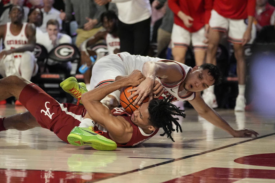 Alabama forward Jarin Stevenson (15) and Georgia guard RJ Melendez (15) struggle for control of a loose ball in the first half of an NCAA college basketball game Wednesday, Jan. 31, 2024, in Athens, Ga. (AP Photo/John Bazemore)