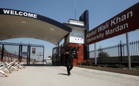 A policeman gestures as he stands guard at the entry of Abdul Wali Khan University where Mashal Khan, accused of blasphemy, was killed by a mob, in Mardan, Pakistan April 14, 2017.REUTERS/Fayaz Aziz