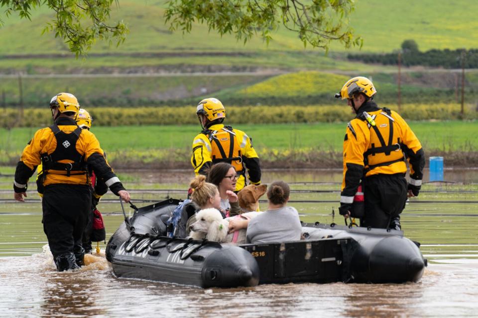 A Swift Water Rescue Teamaids Kirsten Franks, MyKenzie Franks and Tracie franks from their flooded Exeter property.