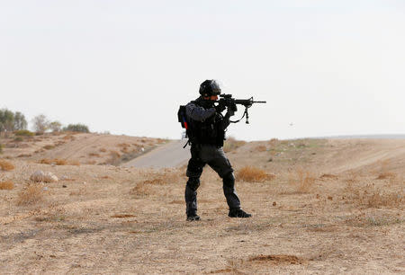 An Israeli border police holds his weapon as he patrols the area following clashes in Umm Al-Hiran, a Bedouin village which is not recognised by the Israeli government, in Israel's southern Negev Desert January 18, 2017. REUTERS/Ammar Awad