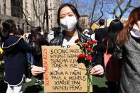 <p>Amy Zhao holds up flowers and a sign with the names of the eight victims who died in the <a href="https://people.com/crime/son-of-atlanta-shooting-victim-hyun-jung-grant-recalls-their-last-moment-together/" rel="nofollow noopener" target="_blank" data-ylk="slk:Atlanta spa shootings;elm:context_link;itc:0;sec:content-canvas" class="link ">Atlanta spa shootings</a> at the Rally Against Hate in New York City's Columbus Park on March 21.</p>