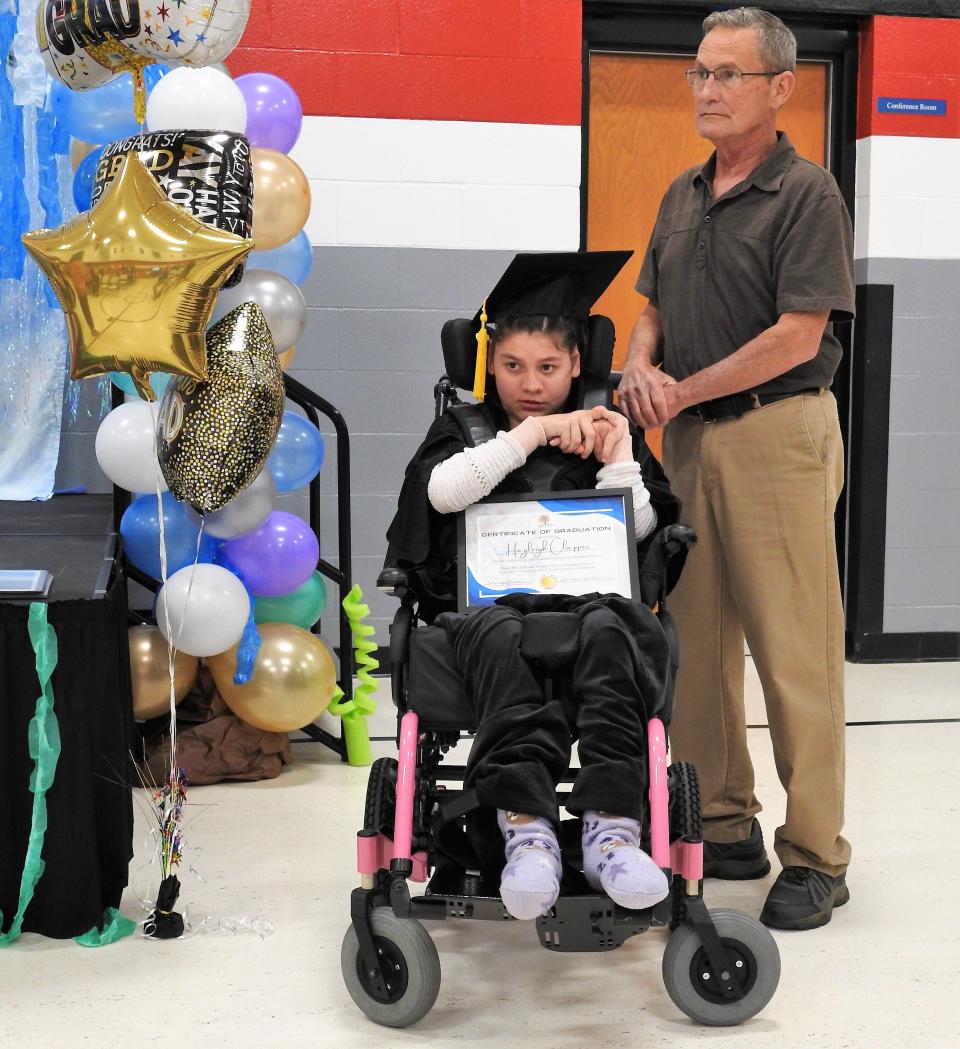 Hayleigh Clapper holds her graduation certificate with paraprofessional Dick McCune. She was one of two graduates from the Transitions program of Hopewell School for the developmentally disabled. The other was Joseph Raber.