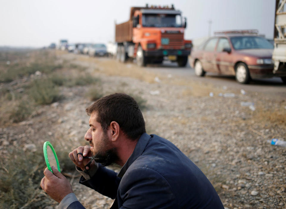 An internally displaced man cuts his beard