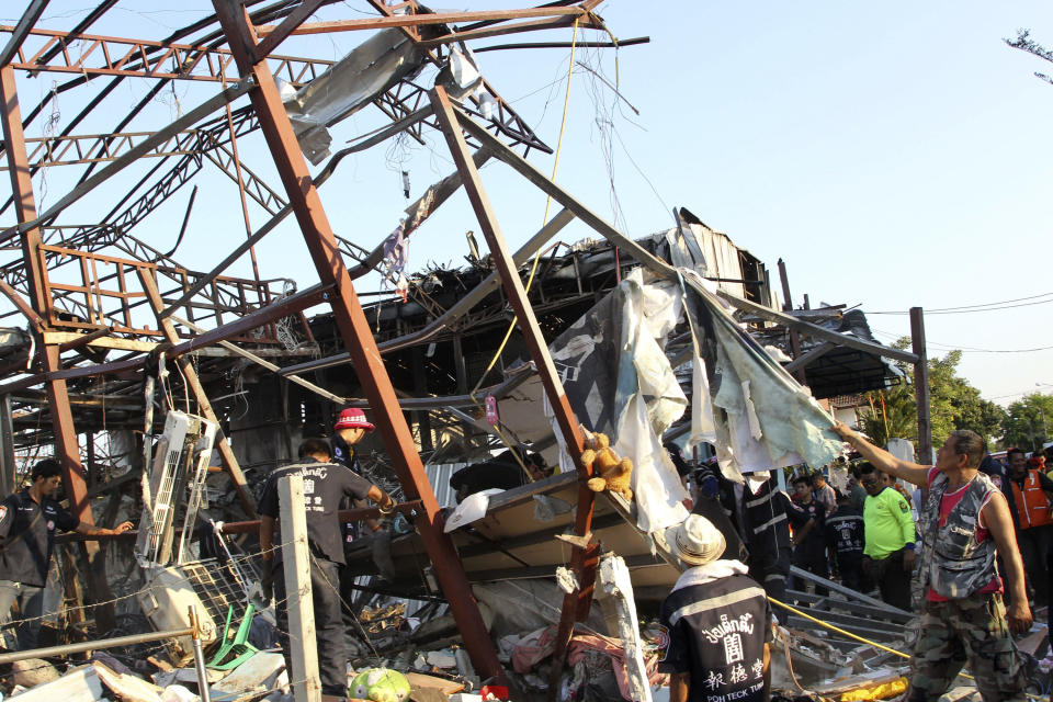 Thai charity workers sift through the wreckage of a building after a bomb explosion at a scrap shop in Bangkok, Thailand Wednesday, April 2, 2014. Workers at the scrap shop in Thailand's capital on Wednesday accidentally detonated a large bomb believed to have been dropped during World War II, killing at least seven people and injuring 19 others, police said. (AP Photo/Apichart Weerawong)