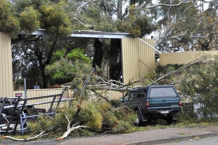 Fallen trees and a damaged building and vehicle can be seen in the town of Blyth, located north of Adelaide, after severe storms and thousands of lightning strikes knocked out power to the entire state of South Australia, September 29, 2016. AAP/David Mariuz/via REUTERS