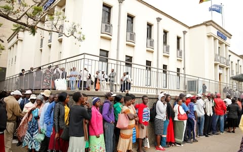 People queue to withdraw money in Harare after Zimbabwe introduced a new currency - Credit: REUTERS/Philimon Bulawayo