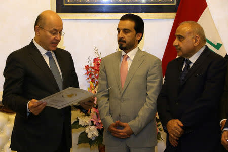 Barham Salih, Iraq's newly elected president (L), swears next to the speaker of Iraq's parliament Mohammed al-Halbousi (C), in Baghdad, Iraq October 2, 2018. Iraqi Parliament Office/Handout via REUTERS