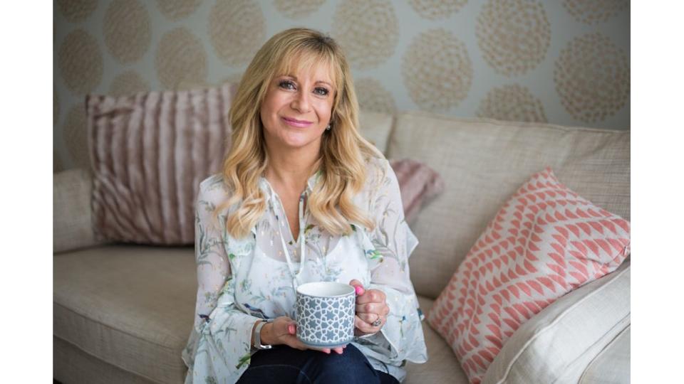 woman wearing a floral top sitting on a sofa