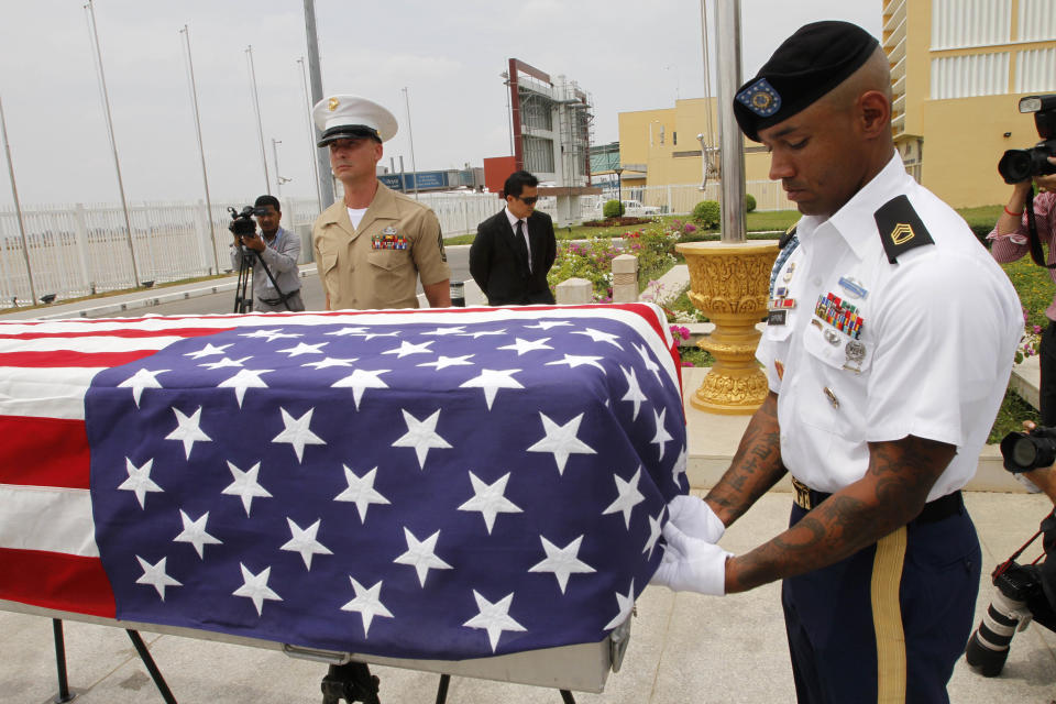 A coffin containing possible remains of a U.S. soldier is draped with the U.S. national flag during a repatriation ceremony at Phnom Penh International Airport, Cambodia, Wednesday, April 2, 2014. The possible remains of U.S. soldiers found in eastern Kampong Cham province were repatriated to Hawaii for testing. (AP Photo/Heng Sinith)
