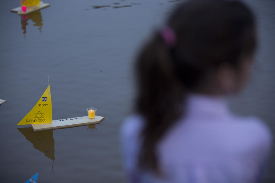 Handmade boats with the names of Nazi concentration camps float in a lake during ceremony marking the annual Holocaust Remembrance Day in Tel Aviv, Israel, Wednesday, May 1, 2019. Israel marking the annual Day of Remembrance for the six million Jewish victims of the Nazi genocide who perished during World War II. Hebrew reads "to remember". (AP Photo/Oded Balilty)