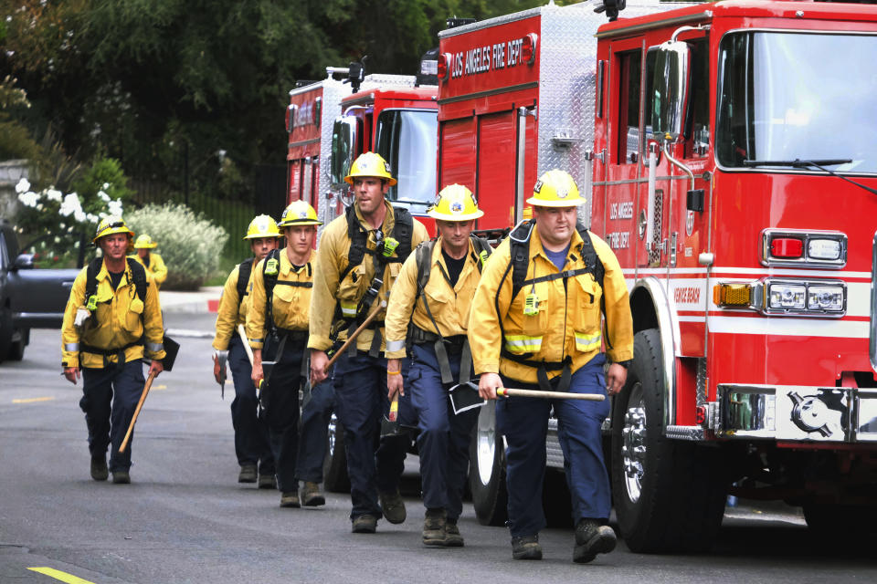 Firefighters walk in line to fight the wildfire in the Pacific Palisades area of Los Angeles, Sunday, May 16, 2021. (AP Photo/Ringo H.W. Chiu)