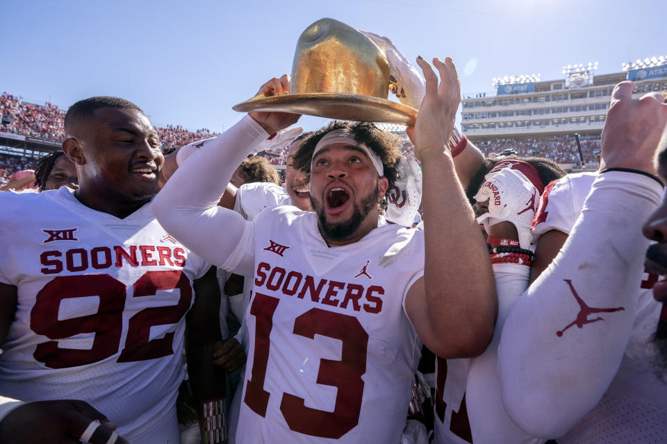 Oklahoma quarterback Caleb Williams (13) puts on the Golden Hat after coming off the bench to lead Oklahoma to a 54-48 win over Texas in an NCAA college football game at the Cotton Bowl, Saturday, Oct. 9, 2021, in Dallas. (AP Photo/Jeffrey McWhorter)