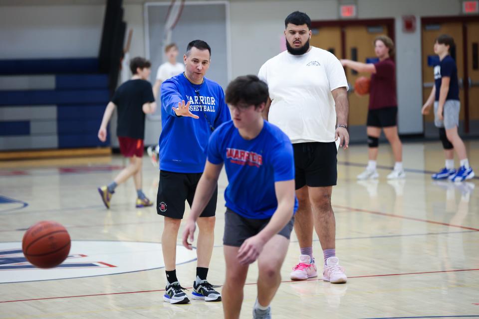 Winnacunnet High School boys basketball head coach Jay McKenna, left, and assistant coach Seth Provencher watch players in a 3-on-3 drill during Tuesday's practice.