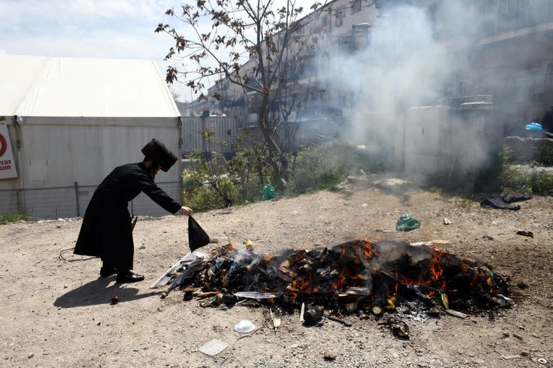 An Ultra-Orthodox Jewish man burn leaven in the Mea Shearim neighbourhood of Jerusalem ahead of the Jewish holiday of Passover amid coronavirus disease (COVID-19) restrictions