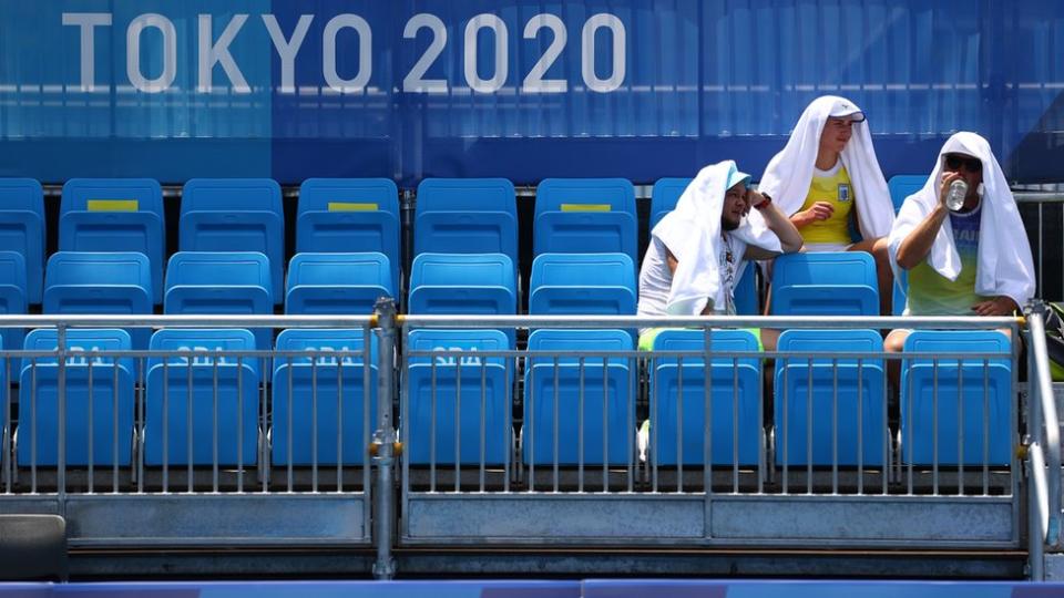 Entrenadores se protegen del calor en el estadio Ariake de tenis en Tokyo 2020