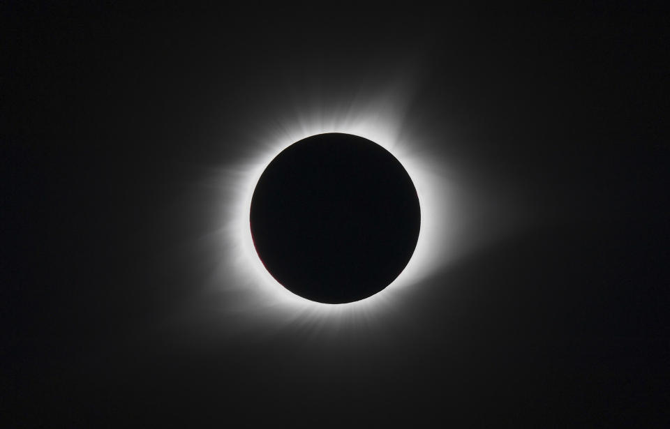 Solar eclipse with the moon blocking the sun's center, creating a glowing halo